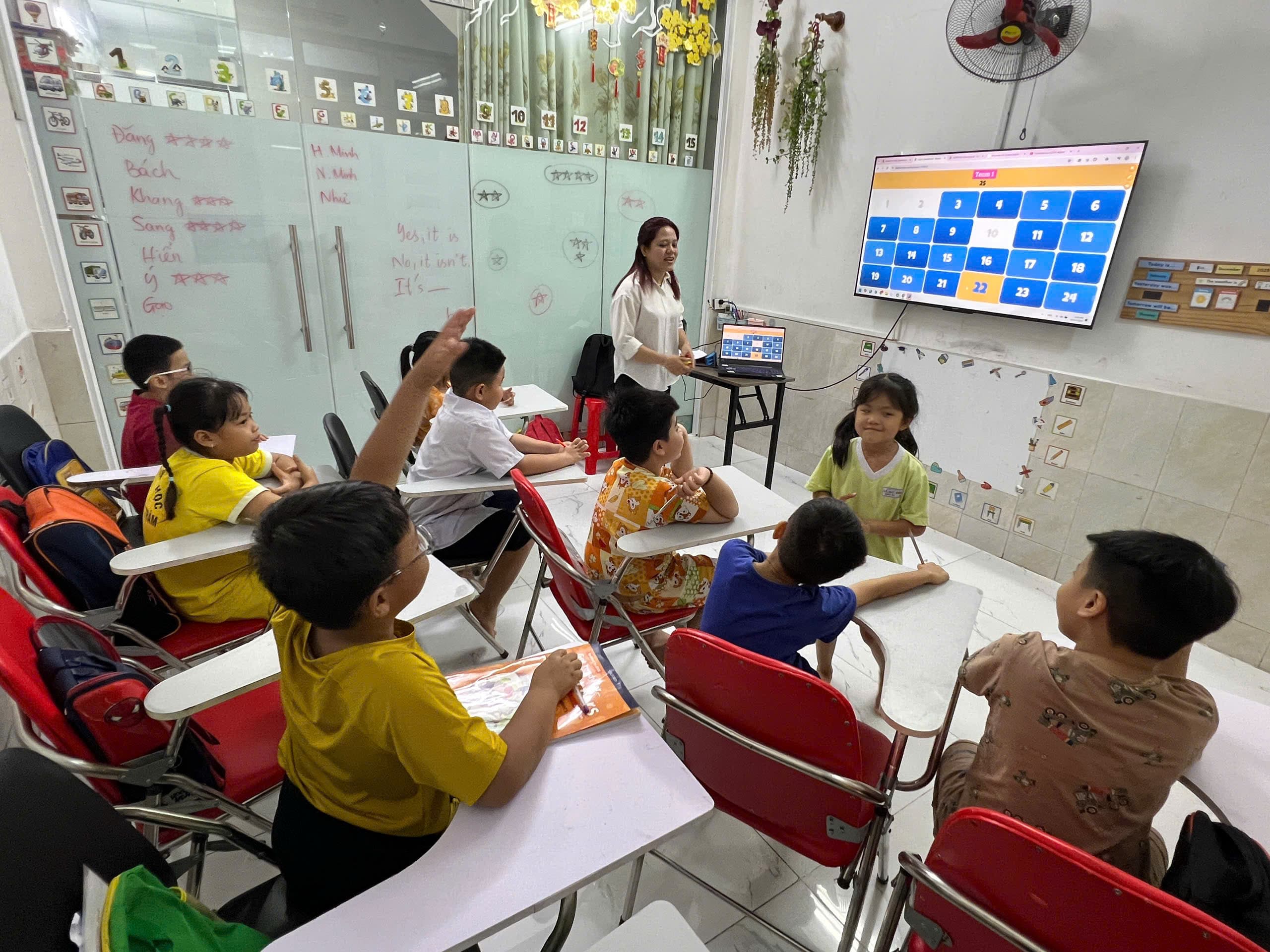 Bé dán thẻ từ lên bảng chủ đề mùa hè