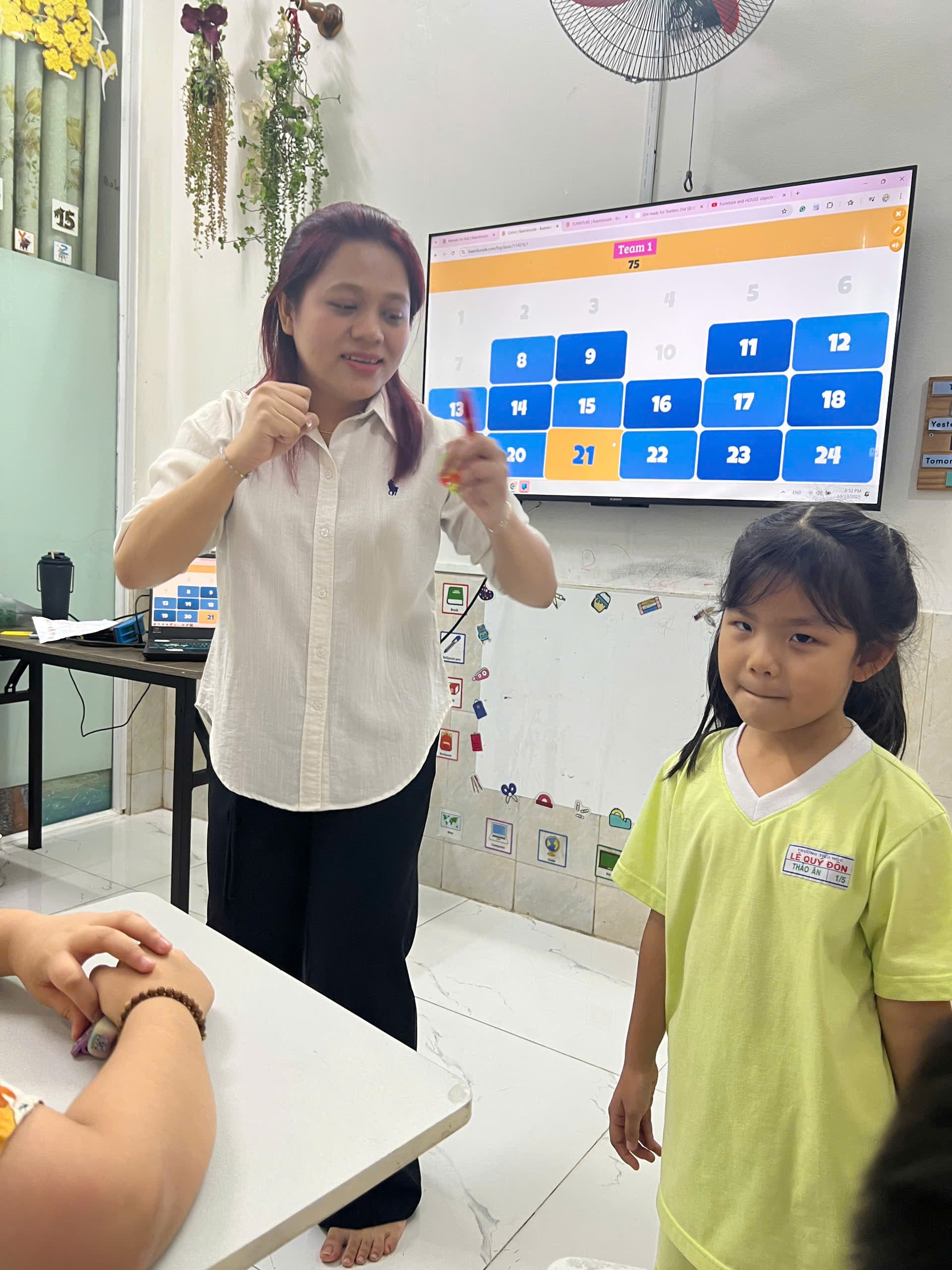 Bé đeo tai nghe và ghi chú khi nghe tiếng Anh